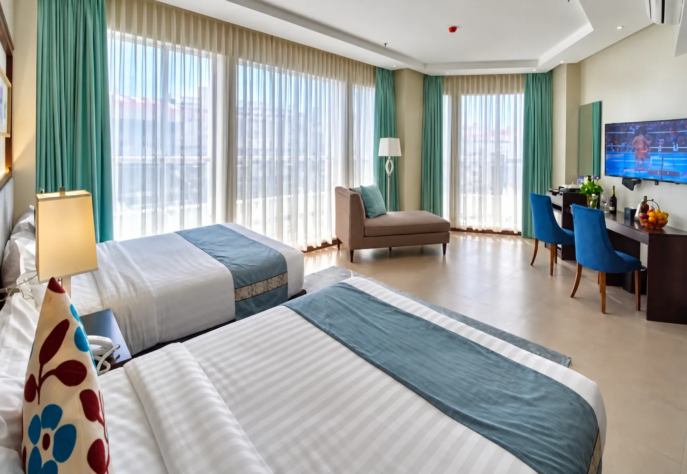 Suite interior with two beds and city-view windows